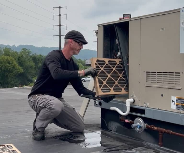 Keath HVAC tech replacing filter on commercial rooftop HVAC unit