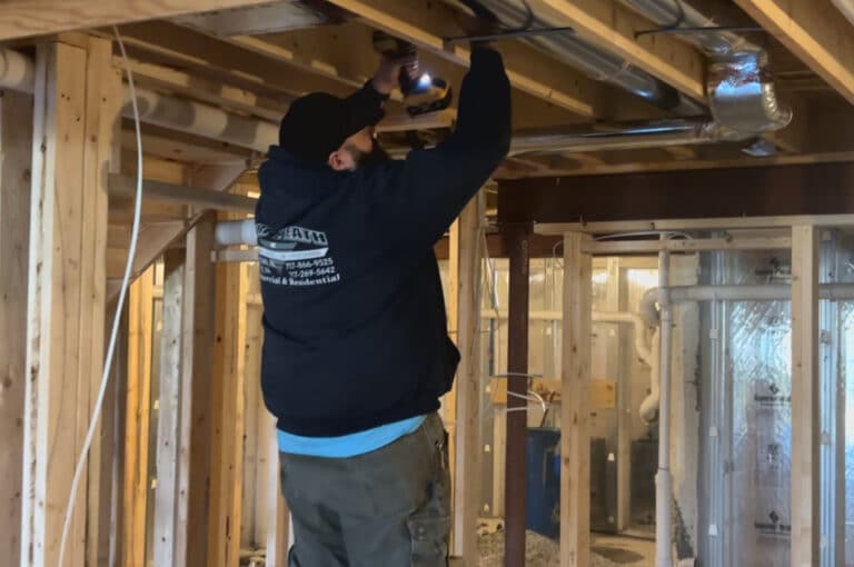 HVAC installer securing duct work to joists.
