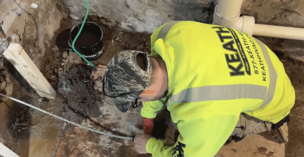 Plumber working on water line repair in customer's basement.