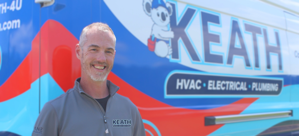 Keath HVAC technician standing next to service van.