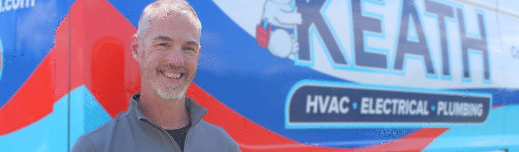 Keath HVAC technician standing next to service van.