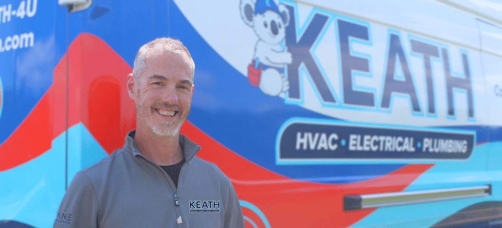 Keath HVAC technician standing next to service van.